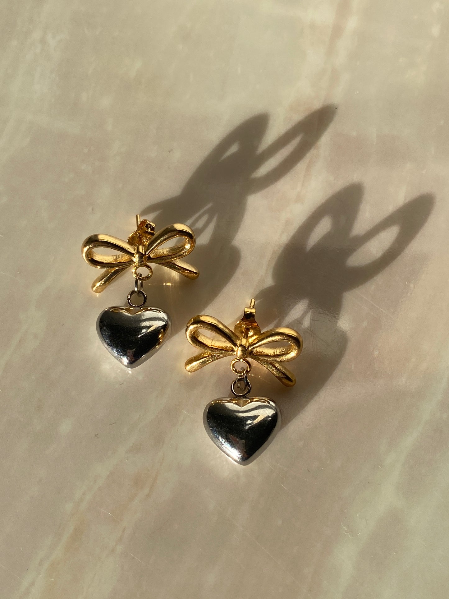 Aretes Corazón y moño plateado con dorado