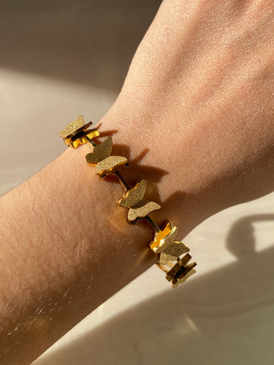 Pulsera dorada con mariposas